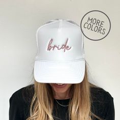 a woman wearing a white trucker hat with the word bride written on it