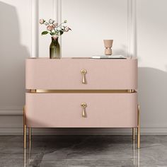 a pink and gold dresser with flowers on top