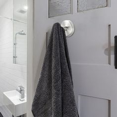 a towel hanging on the wall next to a white door with two pictures above it