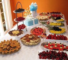 a table topped with lots of different types of pies and pastries on plates