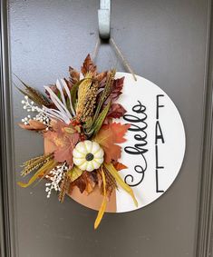 a door hanger decorated with fall leaves and flowers