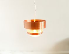 a light that is hanging from a ceiling in a room with white walls and flooring