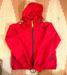 Great retro windbreaker hoodie from the 1990s. Vintage windbreaker jacket by Eastern Mountain Sports. Full zip nylon jacket with kangaroo-style front zipper pockets. Attached stash-away hood with a zippered collar compartment. Separate matching travel bag.  Size: Medium (unisex) Color: Red with green and yellow accents.  Condition: Pre-owned but in great condition with no damages. Material: 100% Nylon Cheap Red Windbreaker For Streetwear, Cheap Vintage Sports Windbreaker, Cheap Multicolor Sporty Windbreaker, Retro Windbreaker, Vintage Windbreaker Jacket, 90s Windbreaker, Mountain Sports, Vintage Windbreaker, Yellow Accents