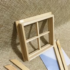 an unfinished wooden window sitting on top of a floor next to pieces of plywood