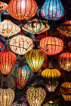 many colorful lanterns are hanging from the ceiling