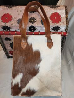 Cowhide Tote - Cowhide Fur Handbag - Brown and White fur handbag on cowhide one side is totally  brown and the other side is white -100% Natural hair on real cowhide leather on both sides of the bag -Genuine Leather Handles  -The interior is silk cloth -the gusset as well as the base of the cowhide tote are made from good quality leather - major compartment with zipper closure  -small zip pocket inside to keep your valuables -mobile phone pocket  Measurment -Height : 35 cm -lenght :   28 cm -Wid Fur Handbag, Fur Handbags, Cowhide Bag, Cow Skin, White Fur, Leather Handle, Cowhide Leather, Purses And Handbags, Inside Pocket