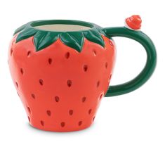 a ceramic strawberry shaped mug with green handles