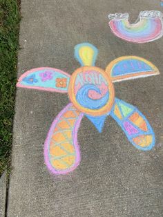 a sidewalk with chalk drawings on it that says honna and an image of a turtle