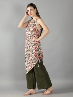 Ivory Floral Print Flower Lace Halter Neck Assymetrical Kurta with Olive Green Flared Pant Cotton ivory floral print kurta with flared pant set will always keep your work day or outing day stylish Assymetrical draw string kurta with halter neckline and flower lace detailing. Pant comes with two side pockets and back elastic wais band. Cotton cambric fabric for relaxed summer look Cold wash and Dry clean only Product doesn't have lining Lining Material: No lining Pattern: Floral Print Fit: Fitted Floral Print Cotton Sets In Maxi Length, Floral Print Cotton Maxi Sets, Casual Sleeveless Festive Sets, Festive Sleeveless Casual Sets, Festive Casual Sleeveless Sets, Floral Print Cotton Pant Set, Spring Sharara With Floral Print And Straight Kurta, Summer Cotton Sharara With Floral Print, Bohemian Floral Print Sharara For Spring