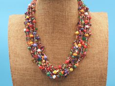 This bright multi strand necklace if full of colorful Czech beads and natural stones. It is the beautiful workmanship by one of our group of Mayan women in the village of Santiago Atitlan, Guatemala. The necklaces' 12 strands can be worn layered or twisted for a more dramatic effect. Each necklace is individually handmade; therefore there may be a slight variance in the placement and color of the natural stones and beads 24 " tip to tip Toggle closure with 3 adjustment loops Multicolored Czech b Artisan Multicolor Multi-strand Beaded Necklaces, Artisan Multicolor Multi-strand Beads, Multicolor Double Strand Beaded Necklace As Gift, Multicolor Double Strand Beaded Necklaces As Gift, Multicolor Double Strand Beaded Necklace For Gifts, Handmade Multicolor Double Strand Beads, Multicolor Polished Beads For Jewelry Making, Artisan Multicolor Gemstone Beaded Necklaces, Multicolor Gemstone Beaded Necklaces