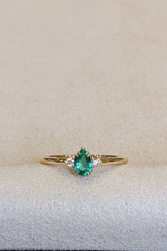 Elevate your style with our stunning 18K yellow gold Three Stone Ring, featuring a captivating 0.30 Ct. emerald flanked by radiant diamonds. This modern design embodies the essence of glamour and sophistication, setting new trends in jewelry fashion. Whether it's a gift for a special someone or a self-indulgent treat, this non-traditional gemstone ring is a symbol of elegance and refinement. Embrace the beauty of custom jewelry and make a statement with this exquisite piece that transcends traditional norms. Luxury 14k Gold Emerald Ring For Formal Occasions, Luxury Pear-shaped Emerald Ring For Formal Occasions, Elegant Yellow Gold Emerald Ring For Formal Events, Elegant Yellow Gold Emerald Ring For Formal Occasions, Luxury Pear-shaped Emerald Ring With Prong Setting, Elegant Birthstone Ring With Prong Setting For Proposal, Elegant 14k Gold Emerald Ring For Formal Occasions, Classic White Gold Emerald Ring For Proposal, Elegant Emerald Jewelry For Wedding Proposal