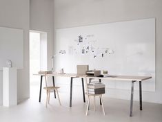 a white room with two desks and chairs