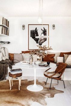 a living room filled with furniture and a white table topped with a vase full of flowers