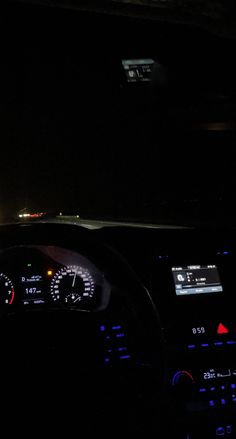 the interior of a car at night with dashboard lights and gauges lit up in the dark