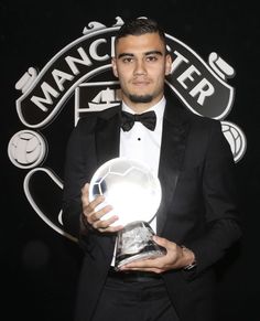 a man in a tuxedo is holding an award for best performance at a sporting event