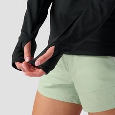 a woman in green shorts holding her hand on her hip