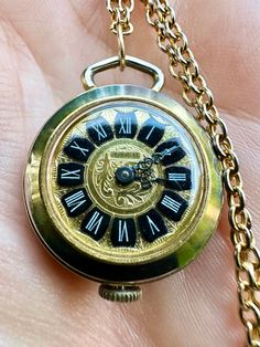 For sale is this charming vintage gold plated watch pendant on a long gold tone throw-over chain. This terrific watch is made of gold plated metal with delightful foliate embossed detail to the back and front. The clock face reads 'Cardinal' and manually winds up via a dial at the top. Appears to run well and is in good working order and condition.  Watch measures 2.5cm in diameter Chain measures 26 inches Sold as seen in pictures Good used vintage condition I can post worldwide, please feel free to ask questions  Thank you! Gold Victorian Style Pocket Watch For Formal Occasions, Victorian Engraved Gold Watches, Gold Hallmarked Pocket Watch, Gold Timeless Hallmarked Pocket Watch, Timeless Gold Hallmarked Pocket Watch, Antique Gold Collectible Watch, Classic Gold Hallmarked Pocket Watch, Antique Gold Watch For Collectors, Vintage Hallmarked Yellow Gold Pocket Watch