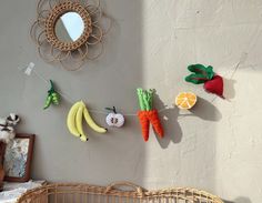 there is a baby crib with fruits and vegetables hanging from it's clothesline