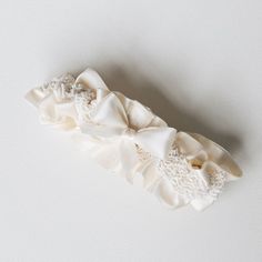 The one and only! Detailed with a peek-a-boo bow in the back for only the most classic of brides and delicate ivory, pearl-like beads throughout the design, this wedding heirloom is timeless in every way. Our 'Aisle Always Love You' style wedding garter is the perfect heirloom to meet your match at the end of the aisle. Details Production Shipping Sizing Main Garter: Light ivory satin background with a stripe of ivory pearl-like beaded trim with an oversized ivory satin bow with short tails tied Bride Garter Photography, White Garter Bridal, Unique Garters Bridal, Personalized Wedding Garter, Custom Wedding Garter, Satin Background, Shimmer Shine, Heirloom Wedding, Perfect Bride