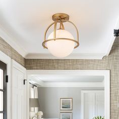 a living room filled with furniture and a light fixture hanging from the ceiling over a couch