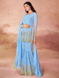 This gorgeous set includes a sky-blue color georgette suit with intricate embroidery and sequin work, a matching georgette sharara with the same delicate detailing, and a dupatta adorned with embroidered sequin work, and designer lace work. The sharara suit comes fully stitched and is available in XS to XXL sizes, ensuring a perfect fit for everyone.
This sky-blue sharara suit is endless. Not only does it offer a stunning and unique look, but you can also wear it to festivals, functions, and eve Umbrella Sharara Designs, Umbrella Sharara, Festive Light Blue Sharara With Intricate Embroidery, Fitted Light Blue Bollywood Salwar Kameez, Unstitched Light Blue Georgette Sets, Blue Chinon Sharara With Intricate Embroidery, Bollywood Style Light Blue Semi-stitched Salwar Kameez, Light Blue Fitted Georgette Dupatta, Fitted Light Blue Sharara With Resham Embroidery