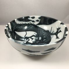 a black and white bowl with a dragon on it