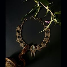 This statement piece rings with mystery and glamor.  This amulet is made from the skin shed of our sweet and pampered ball python, Tutu.  When a snake sheds her skin, it’s a powerful reminder that we have the ability to change old patterns and create a new version of ourselves. A piece of Tutu’s shed resides under glass and is set on top of a colored paper to bring out the beautiful texture of her scales. This pendant features a Tutu-shed centerpiece surrounded by 12 labradorite cabochons on fil Spiritual Metal Jewelry In Snake Shape, Spiritual Snake-shaped Metal Jewelry, Luxury Collectible Bronze Jewelry, Engraved Metal Snake-shaped Jewelry, Bronze Snake-shaped Jewelry For Gift, Unique Oval Jewelry For Ceremonial Occasions, Luxury Bronze Metal Jewelry, Antique Gold Snake-shaped Jewelry, Unique Snake-shaped Metal Jewelry