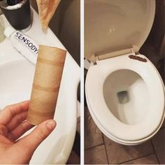 a person holding a roll of toilet paper in front of a toilet with the lid up