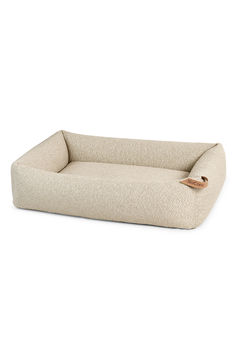 the dog bed is made from fabric and has a leather tag on it's side