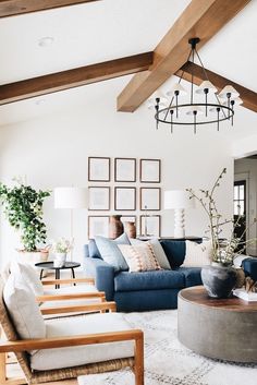 a living room with couches, chairs and pictures hanging on the wall above them