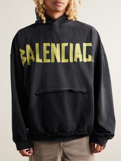 This hoodie features Balenciaga's 'Tape Type' logo, designed to imitate a cool, DIY project. It's cut for an oversized fit from fleece-back cotton-jersey and has a 'ripped' kangaroo pocket for a heavy dose of the label's iconic distressing. Relaxed Fit Logo Hoodie For Fall, Urban Hoodie Sweatshirt With Logo, Fall Hoodie With Logo In Relaxed Fit, Fall Hoodie With Logo And Relaxed Fit, Fall Relaxed Fit Hoodie With Logo, Urban Oversized Hoodie With Logo Print, Oversized Urban Hoodie With Logo Print, Oversized Winter Hoodie With Logo, Fall Hooded Hoodie With Logo Detail