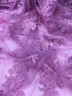 purple lace fabric with flowers and leaves on it's edges, as seen from above