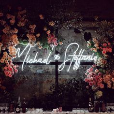 a lighted sign that says medical affair surrounded by flowers and wine bottles on a table