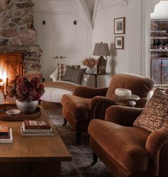 a living room filled with furniture and a fire place next to a couch in front of a fireplace