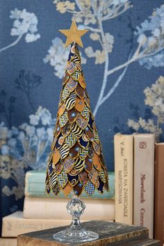 Gold Christmas tree, Christmas table decoration This original and unique decoration was made from scraps of silk. It measures approx.  11 inches  (28 cm). All the small pieces of fabric were each cut by hand and glued to a styrofoam cone. The edges of each piece are dipped in glitter.  The whole tree sits on a beautiful glass stand. There is a small, light, wooden star on the top. Have a look at other offers of Christmas tree:  https://www.etsy.com/pl/shop/moffka?ref=shop-header-name&listing_id=1325258478&section_id=44223404 Please check my other listings (pinecone) and combine  a nice set of Christmas decor: https://www.etsy.com/pl/shop/moffka?ref=seller-platform-mcnav&section_id=39399592 You may also have a look at my other Christmas decorations made from yellowed old book pages: https:/ Lace Christmas Tree, Gold Christmas Decor, Christmas Table Decoration, Fabric Tree, Fabric Christmas Trees, Cone Christmas Trees, Unique Christmas Ornaments, Luxury Christmas, Paper Christmas Tree