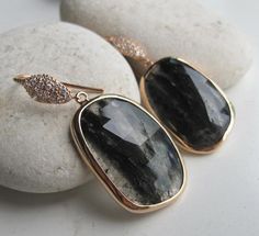 A statement pair of rose gold plated sterling silver black quartz dangle earrings featuring gorgeous streaks of black, accented with sparkly white crystal ear wire. Only one made, makes a one of a kind gift!  Wrapped in a Belesas branded box ready for gift giving.(E.sapphire.7)The lovely gemstone measure 30mm x 20mm*LIKE* us on Facebook http://www.facebook.com/Belesas to find special coupon codes,*FOLLOW* us on Twitter https://twitter.com/#!/Belesas to get more exclusive coupon codes*All item ar Earrings Sapphire, Rose Gold Earring, Elongated Oval, Earrings Stone, Black Quartz, Rectangle Earrings, Earrings Gemstone, Birthstone Earrings, Birthstone Earring