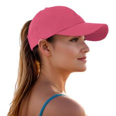 a woman wearing a pink visor and blue tank top with her hair in ponytail