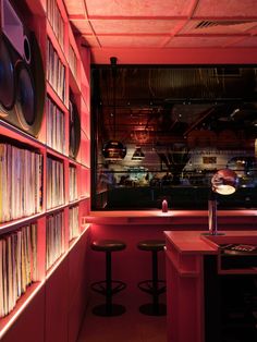 a room filled with lots of books next to a wall full of cds and records