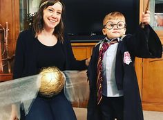 a woman standing next to a little boy holding a golden ball