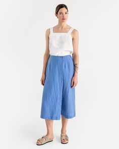 These unique linen culotte pants BUSAN in blue stripes blend style and comfort seamlessly. They come with an elastic back waist for comfort, front seams for a tailored look, and a discreet zipper closure for ease of wear. The skirt element is enhanced with a coconut button, adding a fashionable detail, while side pockets provide convenient utility. Details: * Loose fit * 3/4 length * Elasticated waist at the back  * Pants feature a secret zipper closure * Skirt part finished with a coconut butto Summer Wide Leg Bottoms With Vertical Stripes, Wide Leg Ankle-length Pants With Vertical Stripes For Spring, Spring Wide Leg Pants With Vertical Stripes, Ankle-length, Spring Ankle-length Wide Leg Pants With Vertical Stripes, Casual Linen Bottoms With Vertical Stripes, Relaxed Fit Striped Wide Leg Pants For Spring, Summer Vertical Stripes Wide Leg Pants, Spring Wide Leg Pants With Vertical Stripes, High-waisted Vertical Stripes Wide Leg Summer Pants