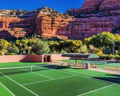 a tennis court with mountains in the background