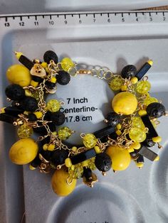 Black and yellow bangle charm bracelet Black Metal Bangle Charm Bracelet, Black Jewelry With Extender For Gift, Black Jewelry With Extender As A Gift, Yellow Metal Bangle Bracelet, Black Charm Bracelet With Lobster Clasp, Black Metal Charm Bracelet, Yellow Beaded Bangle Jewelry, Adjustable Black Charm Bracelet With Lobster Clasp, Adjustable Black Bangle Charm Bracelet