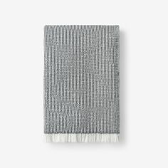 a gray and white towel with fringes on it