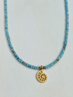 Tranquil Sea Choker Necklace. This stunning necklace combines the calming properties of blue Larimar stone and the harmonious symbolism of the Nautilus Shell creating this dreamy wanderlust necklace. Larimar stone embodies the tranquil energies of the Sea and Sky. It brings the ancient wisdom of Atlantic and the healing power of dolphins to harmonize the body and soul. The gold plated Nautilus shell symbolizes the inner beauty of nature, a symbol of life and internal harmony. Length is approx. 16” with 1” extender. Clasps 14Kt Gold Filled. Spiritual Single Strand Amazonite Jewelry, Bohemian Larimar Natural Stone Jewelry, Bohemian Larimar Jewelry With Natural Stones, Blue Larimar Pendant Necklace, Bohemian Larimar Necklace For Gift, Spiritual Larimar Gemstone Necklace, Bohemian Blue Larimar Jewelry, Handmade Blue Mineral Crystal Necklace, Blue Amazonite Necklaces For Gift