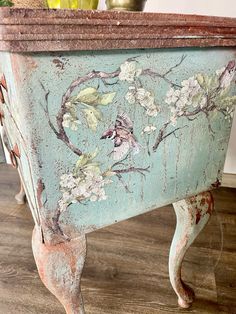 an old blue painted chest with flowers on it