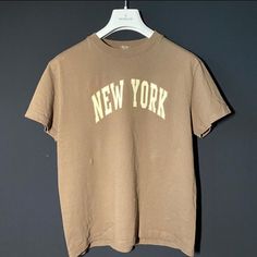 Condition 10/10 Never Worn Brown Text Print Crew Neck T-shirt, Brown Crew Neck T-shirt With Text Print, Brown Crew Neck Top With Letter Print, Brown Letter Print T-shirt With Crew Neck, Tan Crew Neck T-shirt With Letter Print, Vintage Tan Short Sleeve Tops, Vintage Brown Tops For Everyday, Vintage Brown Tops For Everyday Wear, Vintage Brown Top With Text Print