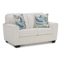 a white couch with two pillows on it