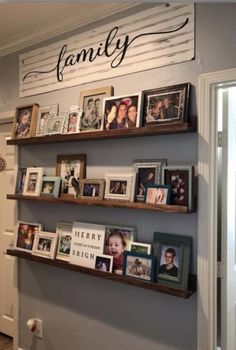 some shelves with pictures and family photos on them in a home's entryway