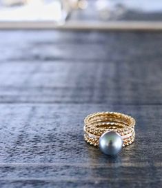 This simple sweet single pearl ring is perfect for pairing with our unique stacking rings, as it's shown in the second picture with 4 of our Enchanted Rings (each sold separately). Pearl size is 9-9.5mm and comes with a standard AA grade pearl. Email us at aloha@keanihawaii.com if you'd like to upgrade to AAA or to a premium pearl color. Read about our Tahitian Pearl grades and policy here. Handmade with love on Maui ♥︎ PLEASE NOTE: This beautiful pearl piece is a custom, handmade-to-order piece Enchanted Rings, Enchanted Ring, Pearl Ring Design, Tahitian Pearls Jewelry, Tahitian Pearl Ring, Pearl Engagement Ring, Pearl Jewels, Single Pearl, Black Pearls