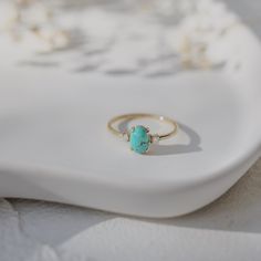 This elegant natural turquoise engagement ring is a perfect blend of unique charm and timeless beauty. The vibrant 4.6 mm oval turquoise takes center stage, flanked by two sparkling diamonds that add a touch of classic brilliance. Material: 14-karat solid gold Gold Colors: Available in yellow, rose, and white gold Turquoise Size: 4.6 mm oval-cut natural turquoise Diamond Details: Two round-cut diamonds, 0.06 ct total weight, G color, VS clarity Design: Turquoise center stone with diamond accents on either side This ring is an exquisite choice for those seeking a distinctive yet sophisticated engagement ring Turquoise Engagement Ring, Turquoise Ring Engagement, Turquoise Gold Ring, Ring With Diamond, Box Making, Solid Gold Rings, Perfect Engagement Ring, Custom Engagement Ring, Charm Gift